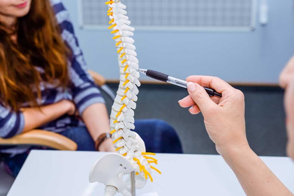 A chiropractor performs an adjustment on a young athlete's shoulder in a clinic setting.