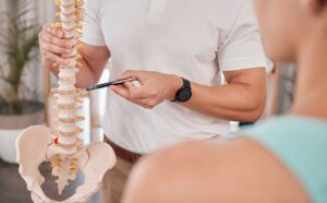 Person discussing abdominal discomfort and back pain with a clinician in a bright examination room.
