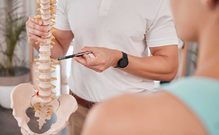 Person discussing abdominal discomfort and back pain with a clinician in a bright examination room.